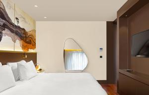 伊斯坦布尔The G Hotels Istanbul的卧室配有白色的床和电视