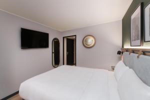 塞尔吉塞日圣克里斯多夫钟楼酒店的卧室配有白色的床和平面电视。