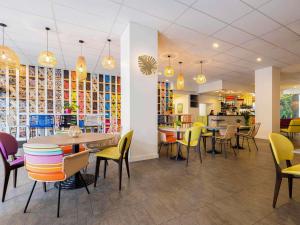佩皮尼昂ibis Styles Perpignan Centre Gare的一间设有五颜六色的桌椅的餐厅和一间自助餐厅