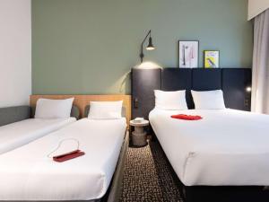 巴黎宜必思巴黎林荫大道歌剧院9e酒店的两张位于酒店客房的床,上面有红色鞋
