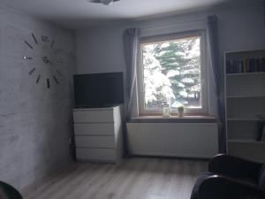 KonarzynyDomek na Kaszubach的客厅设有墙上的时钟和窗户