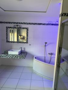 波兹南Willa Euforia的白色的浴室设有浴缸和水槽。