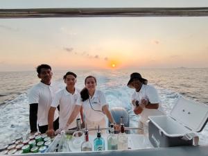 停泊岛Alunan Resort ALL INCLUSIVE的一群人站在海洋中的一艘船上