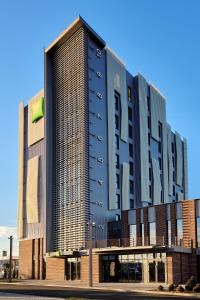 阿拉德ibis Styles Arad的一座高大的黑色建筑,上面有标志