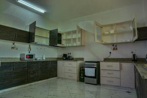 蒙巴萨Fenns Cozy Apartment - Nyali的空厨房,配有木制橱柜和电器