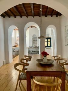 TriandárosThe Artist House的厨房以及带木桌和椅子的用餐室。
