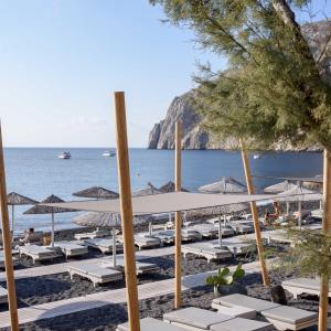 卡马利Afroditi Venus Beach Resort的海滩上的一组躺椅和遮阳伞