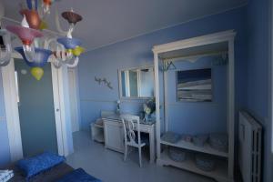 加里波第港B&B Sogno D'Estate的蓝色的客房配有桌子和镜子