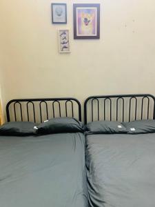 河内Head of Quarter -TRIPLE BED ROOM- CHEAP的卧室内的两张床,墙上挂有照片
