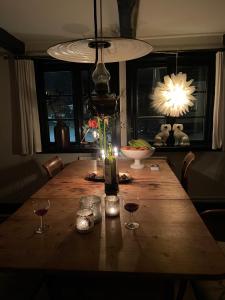 VikenElins Lycka i Viken的一张带酒杯的木桌和一盏灯