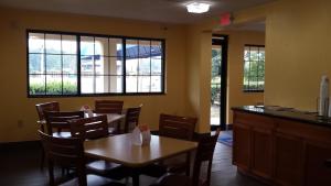 坎普泉Rodeway Inn Joint Base Andrews Area的用餐室设有桌椅和窗户。