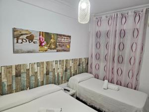 乌特雷拉Pension Hidalgo 1的一间卧室配有两张床和粉红色窗帘