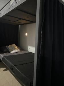 科隆House in Coron-The Grey House的一间卧室配有一张带黑色床垫的双层床