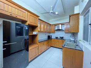 伊斯兰堡Luxury Villa in Islamabad Margala Hills Views的厨房配有木制橱柜和黑色冰箱。