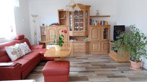 卡尔明茨Ferienwohnung Mioritza的客厅配有红色沙发和木柜