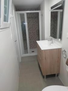 比利亚霍约萨casa de tres habitaciones con parking bajo la casa的白色的浴室设有水槽和淋浴。