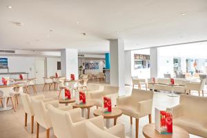 坎帕斯蒂利亚伊卢逊卡尔马Spa酒店的一间设有白色桌椅和红色弓的餐厅