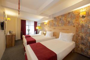 伊斯坦布尔Galata By Boss Hotel的酒店客房带两张床和壁画