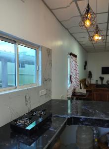 AberdeenKalapani Seaview Service Apartment的厨房配有黑色台面和窗户