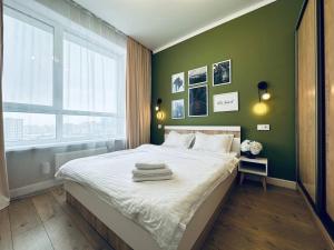 阿斯塔纳Grand Turan Business 2-Room Apartament's的一间卧室设有一张大床和绿色的墙壁
