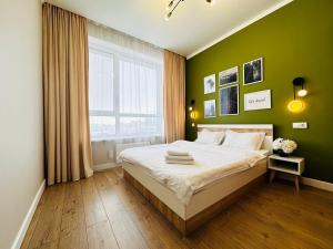 阿斯塔纳Grand Turan Business 2-Room Apartament's的一间卧室设有一张带绿色墙壁和窗户的床。