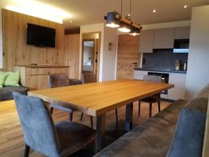米特西尔Aparthotel Hohe Brücke-NPHT Sommercard inklusive的厨房以及带木桌和椅子的用餐室。
