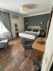 奥朗日Le Clos d'Orange, Hotel & ville de Provence的一间卧室配有一张床、一张桌子和一张沙发