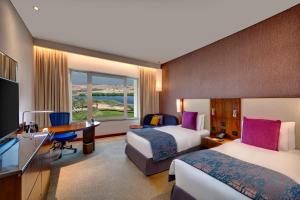 马斯喀特马斯喀特OCEC皇冠假日酒店的酒店客房配有两张床和一张书桌