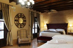 阿拉色那Casa Rural Andalucia Mia的一间卧室配有两张床、一把椅子和镜子