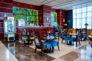 多哈多哈广场酒店的一间带桌椅的餐厅和一间酒吧