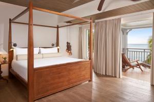 勒莫尔尼瑞吉毛里求斯度假酒店 的一间带四柱床的卧室和一个阳台