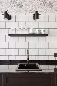 罗列特海岸"Breeze" Aparthotel by Parrot`s House的厨房设有水槽和白色瓷砖墙。
