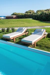 赫索尼索斯贝拉海滩酒店的游泳池畔的两张床