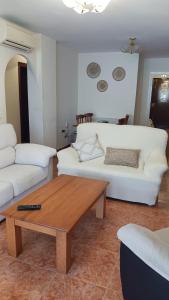 林孔-德拉维多利亚APARTAMENTO PLAYA AZUL的客厅配有白色沙发和茶几