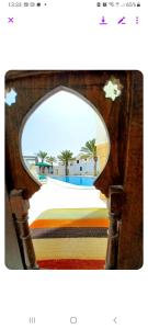 米多恩Maison Leila chambres d hotes的镜子反射着海滩和棕榈树