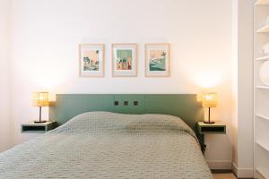 里夫杜海滩La Plage, T2 vue mer的一间卧室配有一张床和两张台灯。