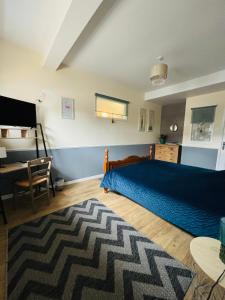 沙托兰Numéro 1的一间卧室配有蓝色的床和一张书桌