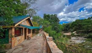SekenaniDan Maasai Mara safari camp的河边的建筑