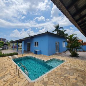 PorangabaCasa em condomínio Ninho Verde 1的蓝色房子前面的游泳池