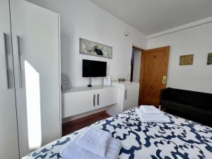 多列毛利诺斯RC La Carihuela by Beehive Vacances的一间白色卧室,配有床和电视