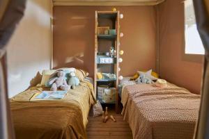 利亚内斯里约普隆营地旅馆的儿童卧室,配有两张床,里面饲养着动物