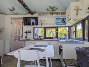 Certeju de SusTheea's tiny house的厨房配有白色橱柜和桌椅