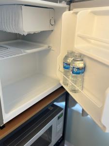 伯明翰Private En-suite的两瓶水坐在一台开放式冰箱内