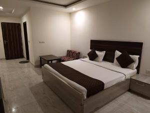 新德里Hotel Samara Kingdom Near Delhi Airport的一间卧室配有一张大床和一把椅子