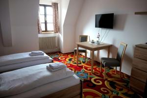 瓦拉什斯凯梅济日奇城堡旅馆的客房设有两张床、一张桌子和电视。