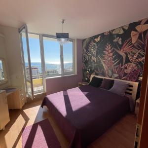 埃勒尼特Crown Imperial Fort Grand Resort的一间卧室设有紫色的床和大窗户