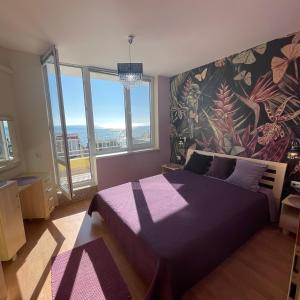 埃勒尼特Crown Imperial Fort Grand Resort的一间卧室设有紫色的床和大窗户