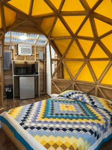 TracadieSam’Relax Plus的圆顶帐篷内的一张床位,圆顶帐篷设有黄色的墙壁