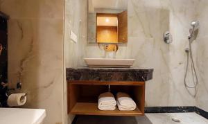 新德里FabHotel Prime Star 17的浴室配有盥洗盆和带毛巾的台面。