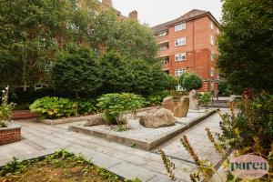 伦敦Parea Living - Stylish Islington 1-Bed Flat, 6min Walk to Tube的砖砌建筑前的花园
